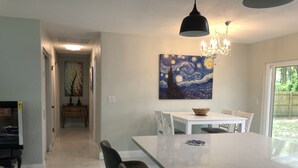 A modern kitchen with a large island, white cabinetry, and a chandelier. - Cozy ,Tranquil 3-bedroom in Spring Hill with WiFi, AC ; home away from home.  (Spring Hill)