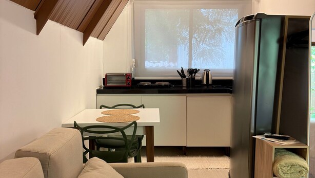 Um espaço compacto com cozinha compacta, área de refeições e espaço para sentar.