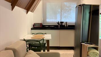 A compact living space with a kitchenette, a dining area, and a seating area.