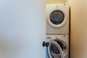 Etukuormattava pesukone, jossa on ohjauspaneeli ja ovenkahva.