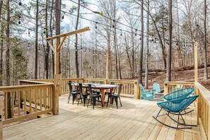 A wooden deck with a table and chairs, surrounded by trees. - Tucked Inn: Upper Unit - 151 Getaway/Wine + Brews (Nellysford)