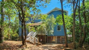 A two-story house with a wooden staircase leading to a deck. - COOL AZUL - 5 bed, 3 bath pool home in Southern Shores, dog friendly (Southern Shores)