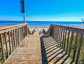 A wooden boardwalk leading to a beach with a sign reading "BONITO".