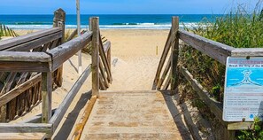 A wooden boardwalk leading to a beach with a sign warning about rip currents. - LADY CORTEZ - 6 bed, 5.1 pool home, dog friendly. Walk to beach AND sound access! (Duck)