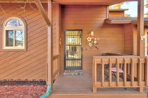 A wooden house with a front porch, a door with a metal gate, and a number '41' above the door.