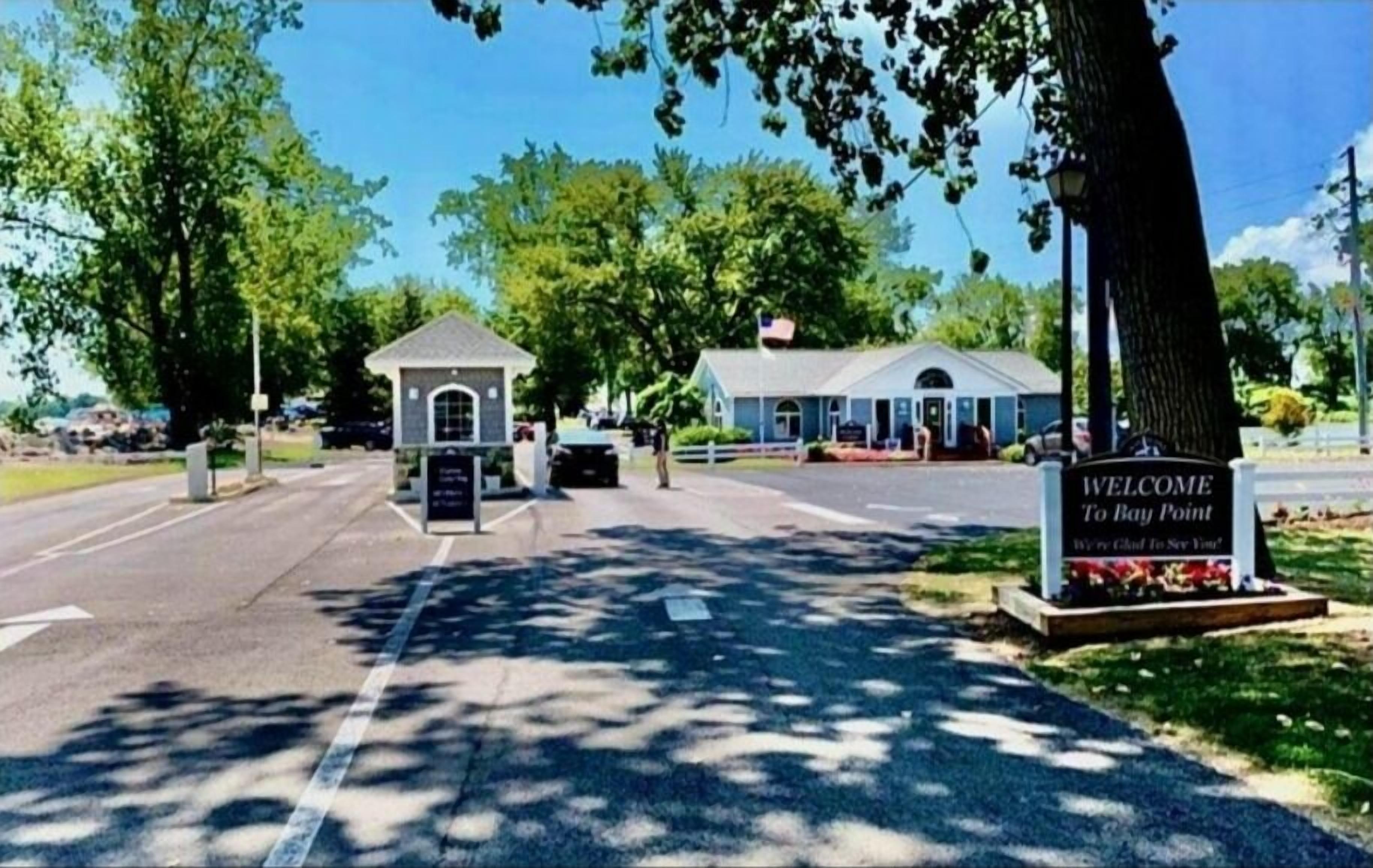 Une pancarte d’accueil à l’entrée d’un bâtiment, avec un petit pavillon et un espace abrité.