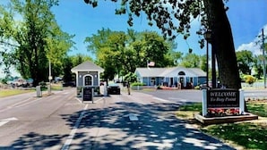A welcome sign at the entrance of a building with a small pavilion and a covered area.
