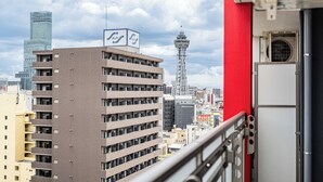A high-rise building with a sign, a tower, and a red structure in the foreground.