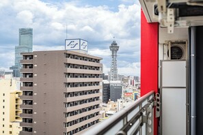 A high-rise building with a sign, a tower, and a red structure in the foreground. - Apartment Hotel 11 Namba-Minami Ebisucho (Osaka)