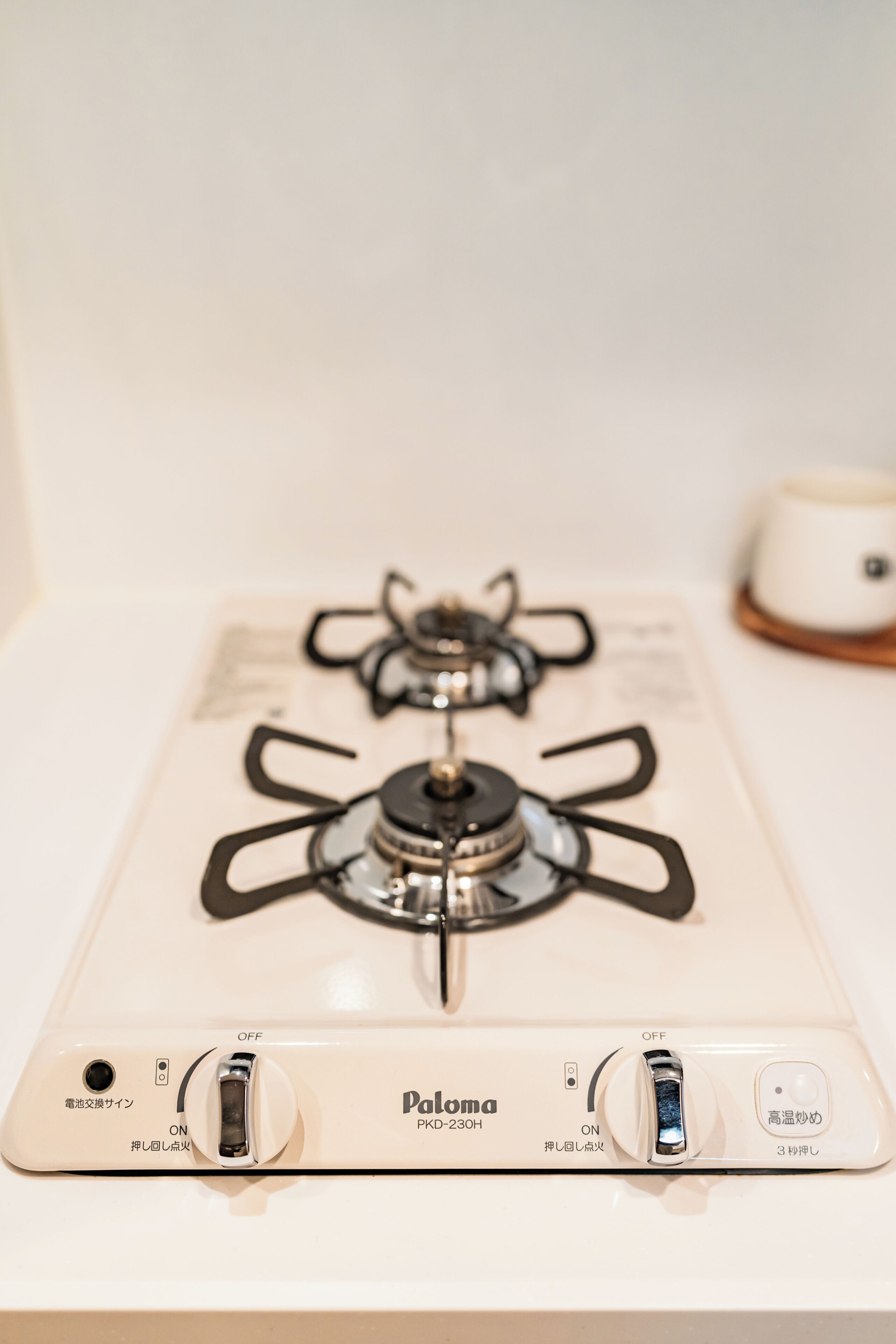 A white gas stove with two burners and a control panel with OFF and ON switches.