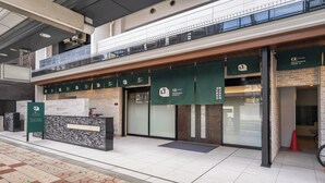 A hotel entrance with a reception desk, a check-in counter, and a glass door entrance.