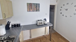 A kitchen with a radiator, a toaster, and a wall clock. - House - Sleeps 4 - Garden - Parking (Wallsend)