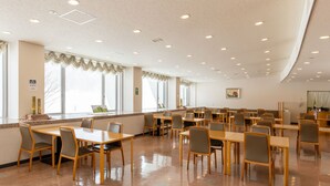 A spacious dining area with multiple tables and chairs, large windows, and a polished floor. - Tabist Heilsam Kurikoma Cottage (Kurihara)