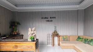 Una habitación con una mesa de centro de madera, un sofá, una mesita auxiliar y una pared con un cartel.