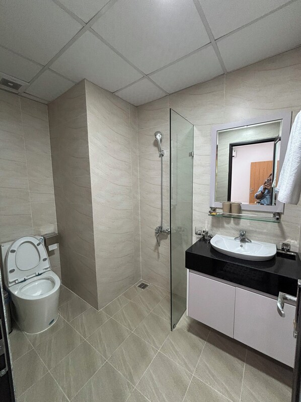 Un baño moderno con inodoro, ducha y lavamanos.