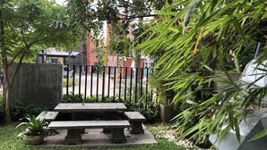A garden area with a picnic table and potted plants.