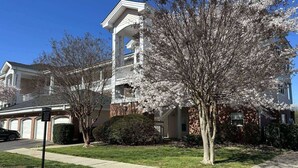 A two-story house with a front porch and a garage. - Relaxing Now and Zen: Modern Condo, Near UNCC, PNC Pavilion, Pool, 5 Min to Dining, Shops, +15% off! (Charlotte)