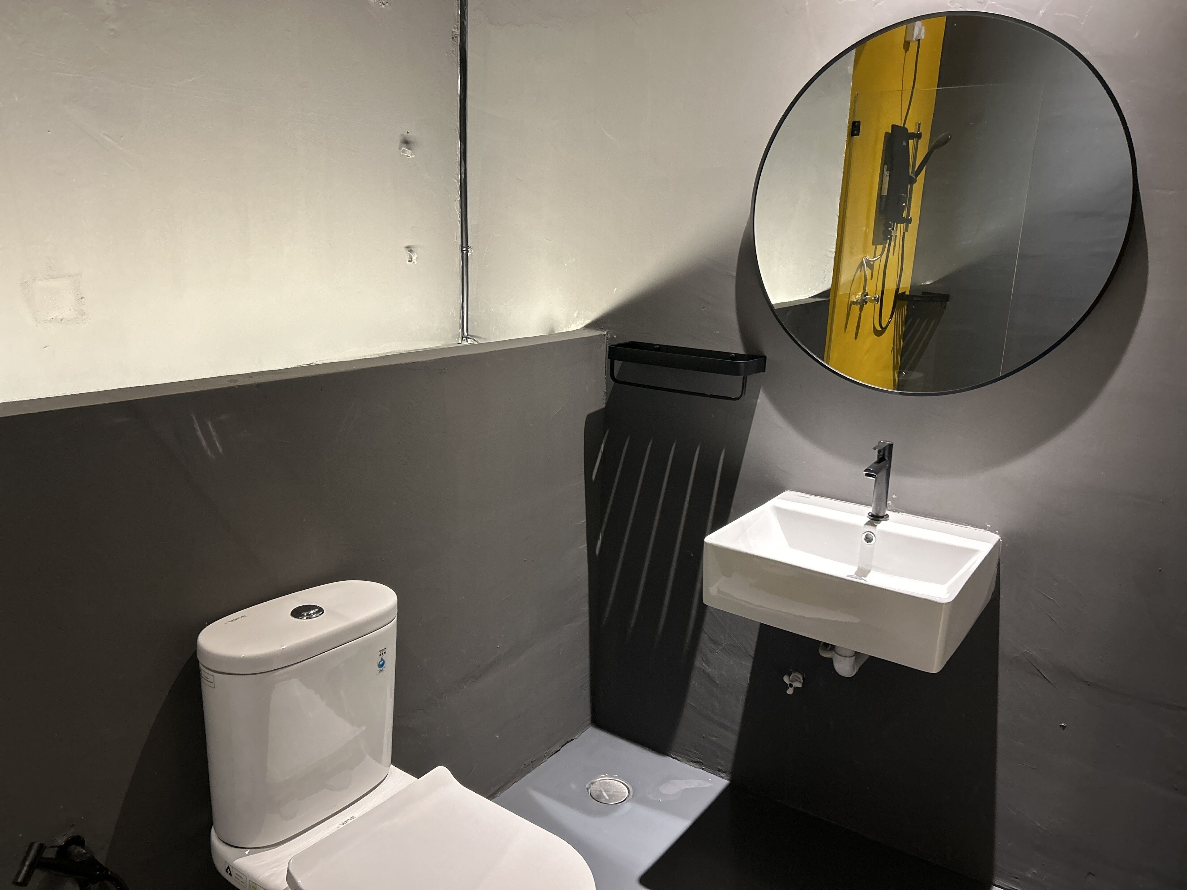 Une petite salle de bain comprenant des toilettes, un lavabo et un miroir.