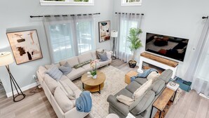Una sala de estar moderna con sofá, mesa de centro y televisor.