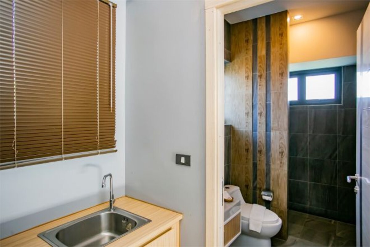 A modern bathroom with a wooden vanity, a sink, and a toilet.