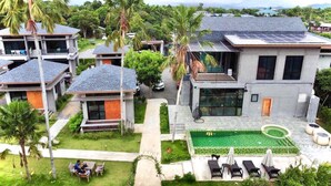A modern residential area with multiple houses, a swimming pool, and a small garden. - ProudChan Boutique Resort (Chanthaburi)
