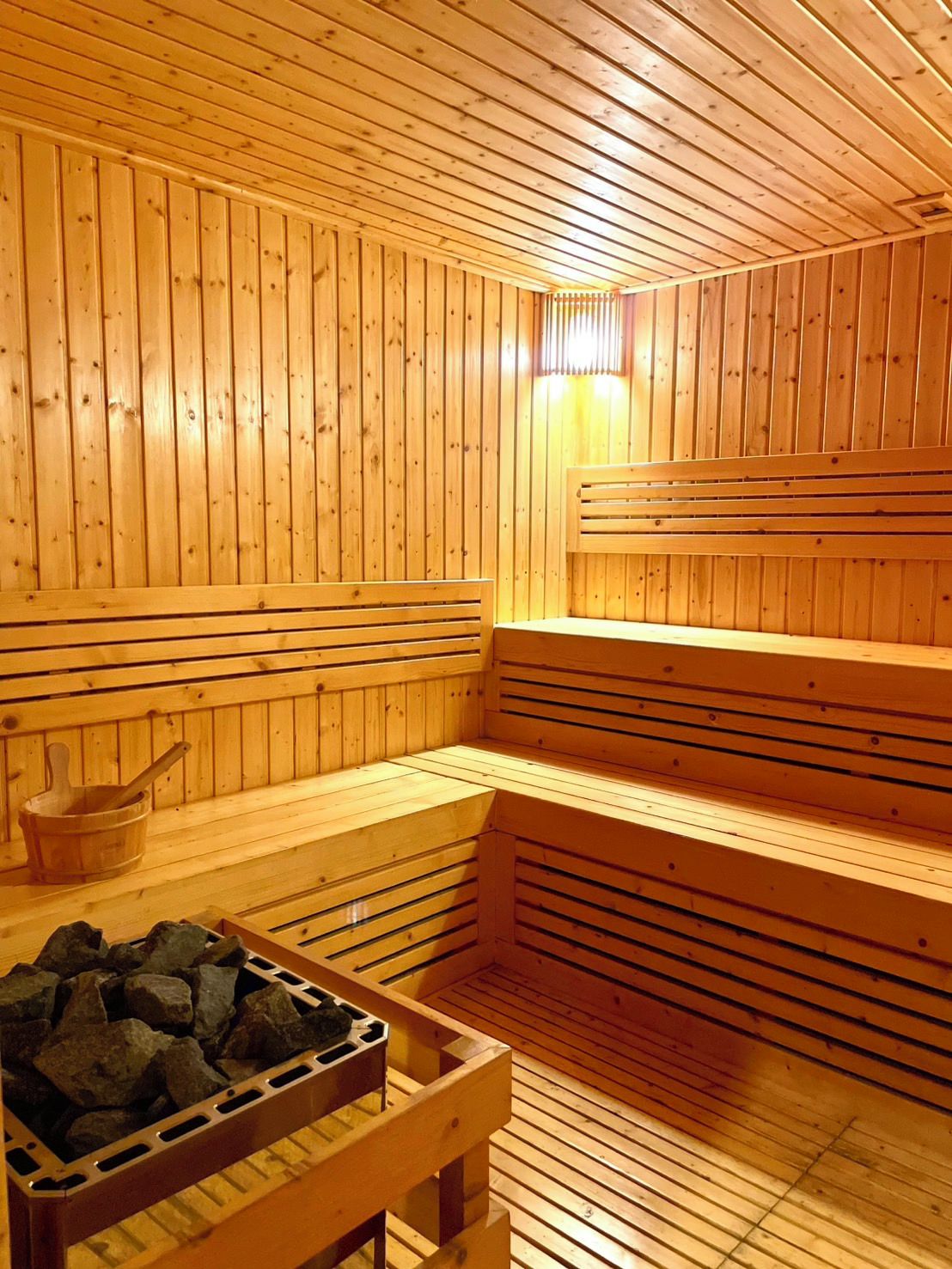 A sauna with wooden benches and a stone basin.