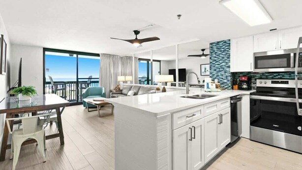 A modern kitchen with a central island, white cabinetry, and stainless steel appliances. - SunDestin 1BR Condo With Bunks, Balcony Views and Sleeps 6 - Unit 0202 (Destin)