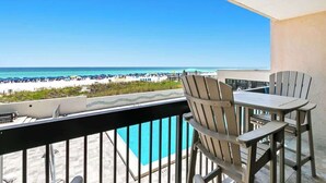 A balcony with a view of the beach, a pool, and outdoor furniture. - SunDestin 1BR Condo With Bunks, Balcony Views and Sleeps 6 - Unit 0202 (Destin)
