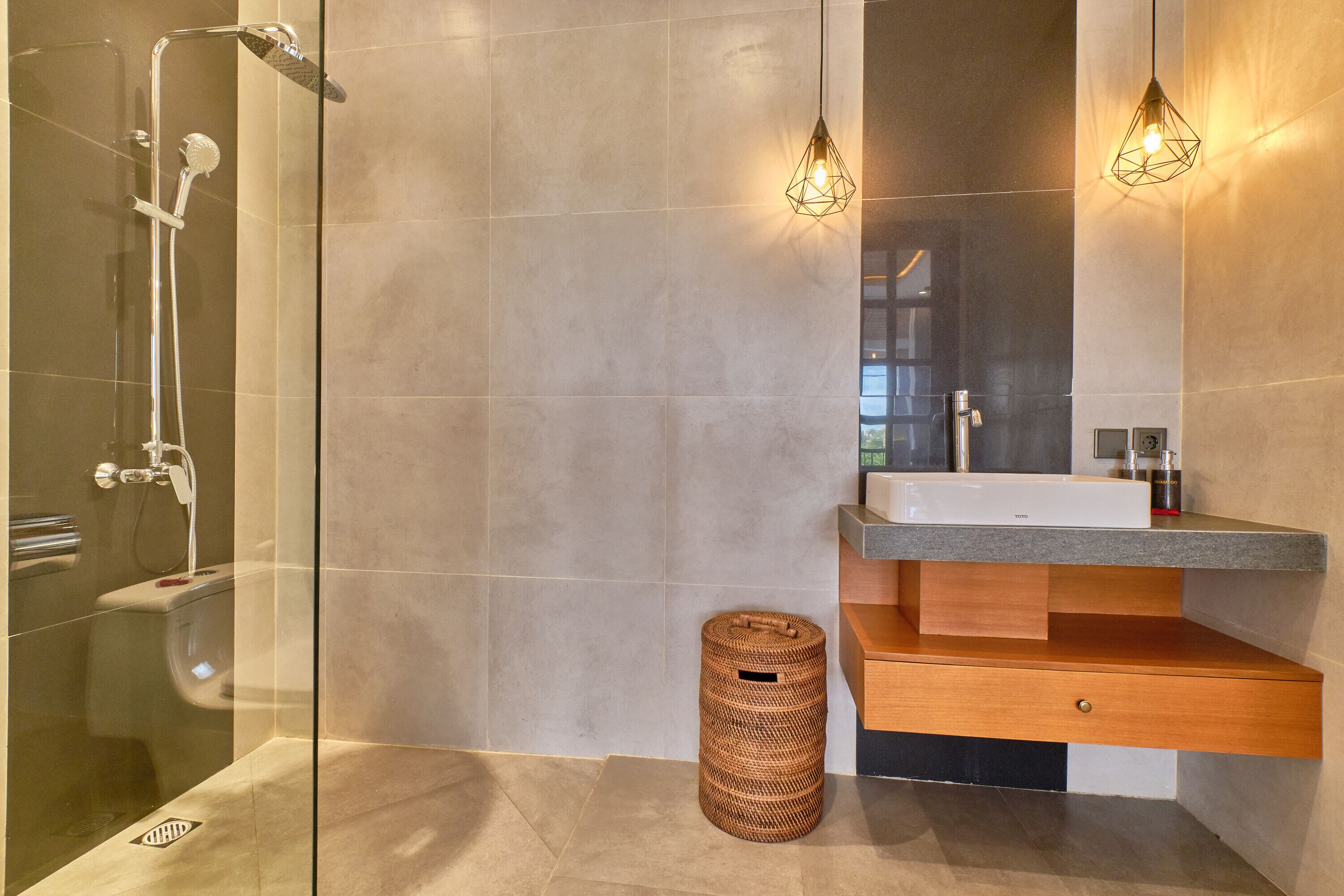 Une salle de bain moderne avec une douche à parois de verre, un meuble-lavabo en bois et un grand miroir.