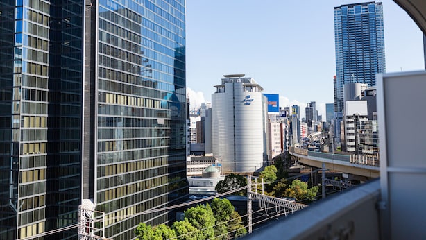 A cityscape with modern high-rise buildings, a bridge, and a water tower. - Apartment Hotel 11 Umeda (Osaka)
