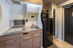 A compact kitchen with a stainless steel refrigerator, a microwave, and a sink. - Apartment Hotel 11 Umeda (Osaka)