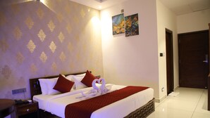 Ein Hotelzimmer mit einem ordentlich bezogenen Bett, einem Nachttisch mit Lampe und einem Bild an der Wand.