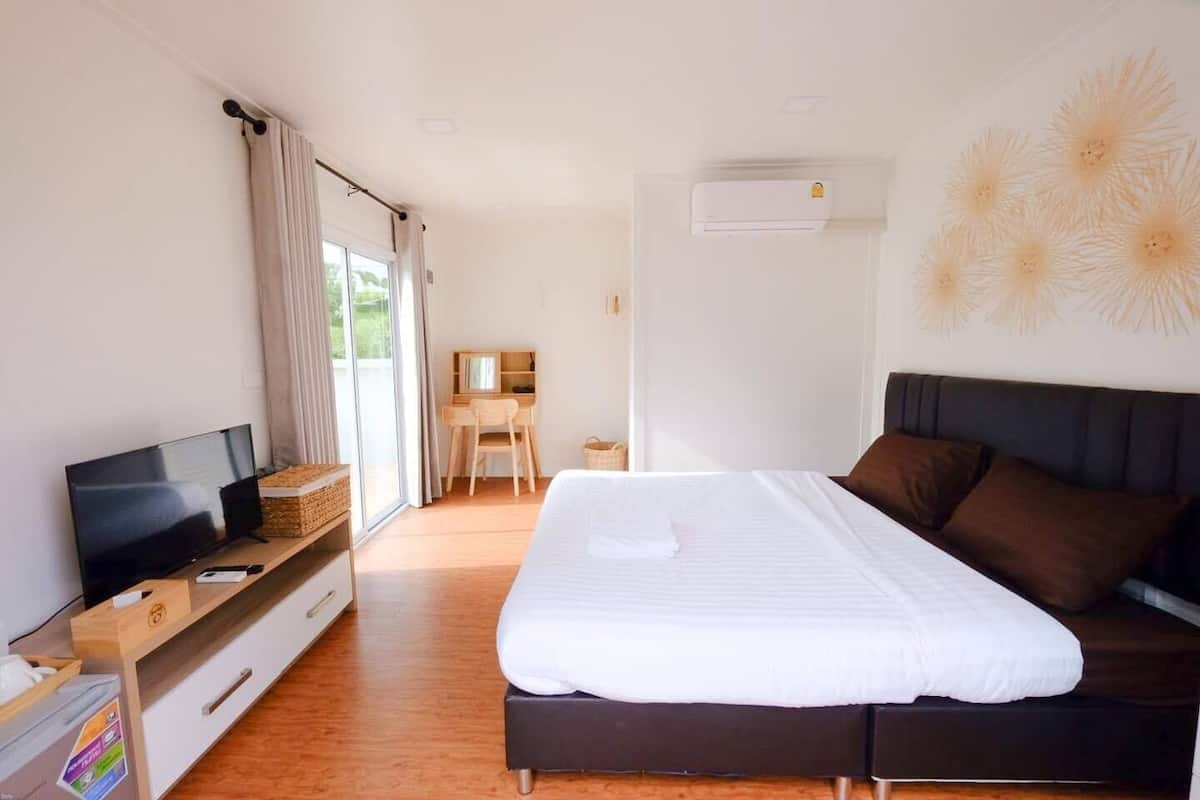 Una habitación de hotel con cama, televisión, escritorio y silla.