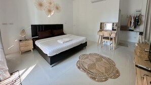 A modern bedroom with a large bed, a desk, and an air conditioning unit. - Baan O Resort (Rayong)