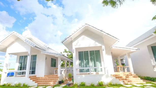 A modern two-story house with a covered porch, large windows, and a well-maintained lawn with stepping stones. - Baan O Resort (Rayong)
