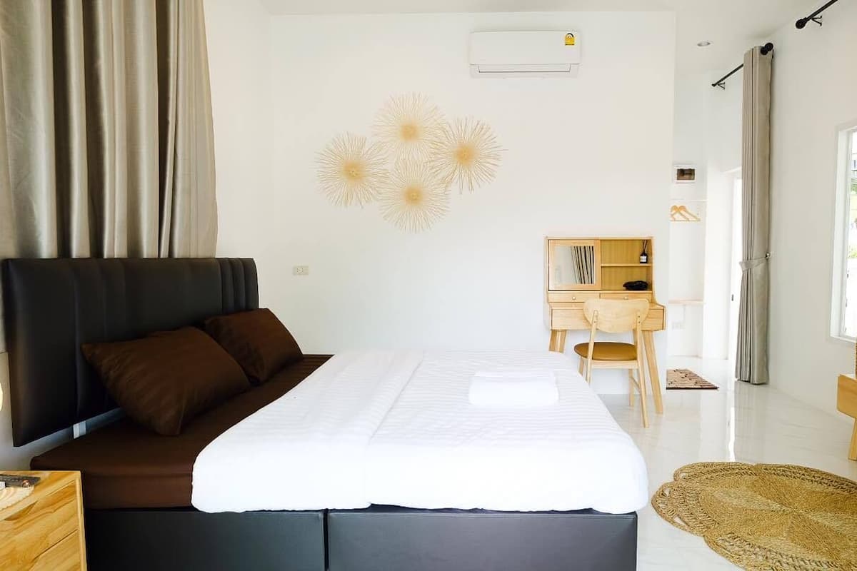 Una habitación de hotel moderna con una cama grande, un escritorio y un televisor.