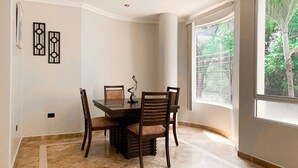 Un comedor con una mesa rectangular, cuatro sillas y una escultura metálica decorativa.