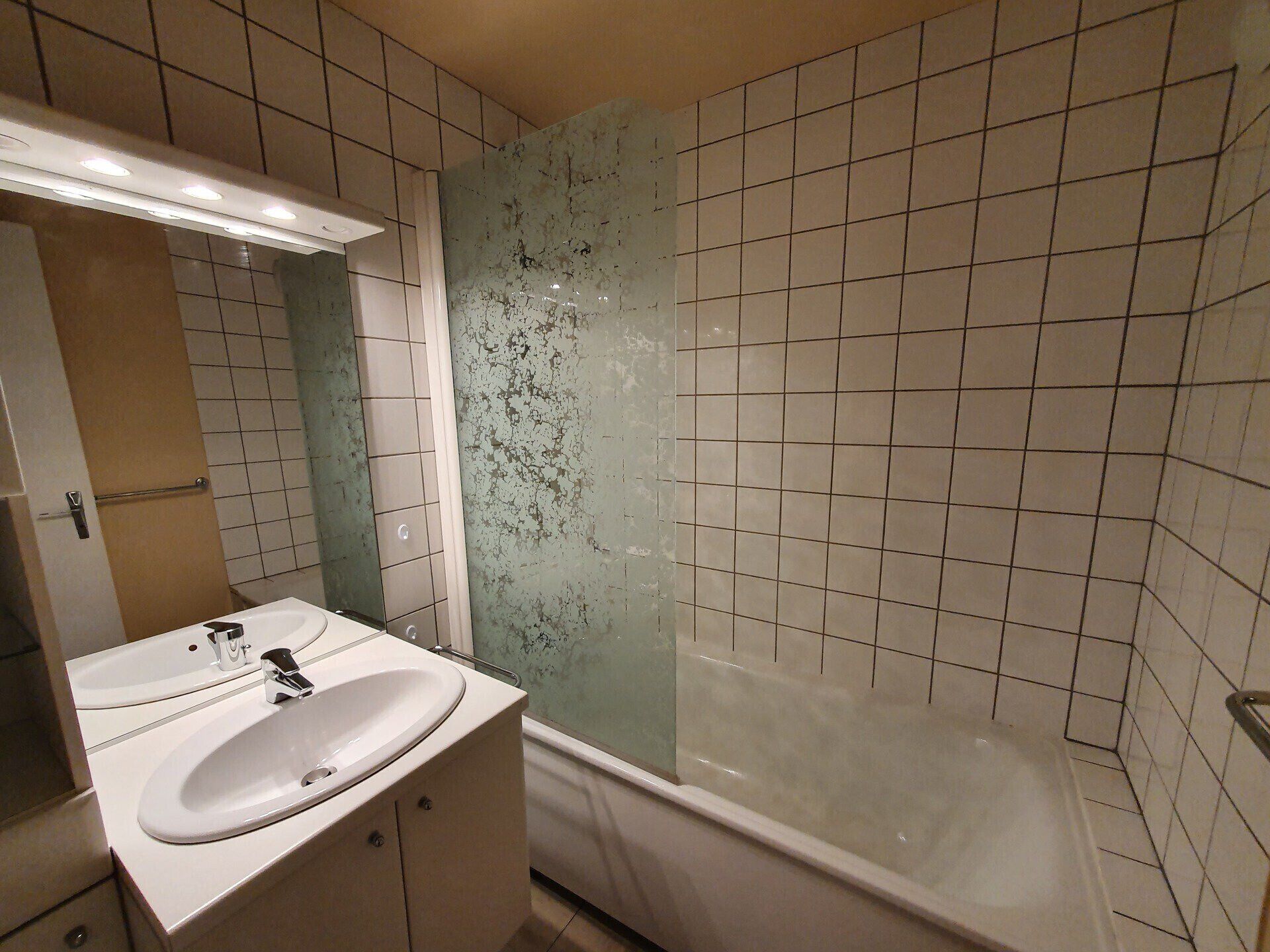 Ein Badezimmer mit Waschbecken, Spiegel und Badewanne.