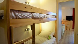A bunk bed with a desk and a television in the background. - Andromede - 35 - Studio coeur station - 4 pers (Les Deux Alpes)