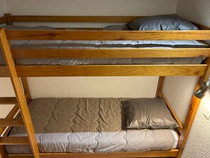 Un lit superposé à deux niveaux, chaque niveau étant équipé d’un oreiller.