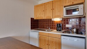 A kitchen with wooden cabinets, a microwave, a coffee maker, and a dishwasher.