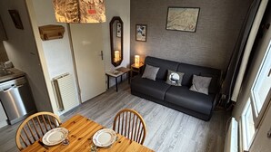A compact living space with a dining area, a sofa, and a kitchen. - Studio 4 ppl near the ski runs (Les Deux Alpes)