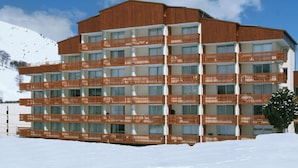 A multi-story hotel with balconies, set against a snowy landscape. - Studio 4 ppl near the ski runs (Les Deux Alpes)