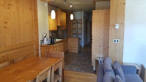 A wooden interior with a dining table, kitchen area, and a sofa. - Nice apt 8 ppl with sapacious terrace (Les Deux Alpes)