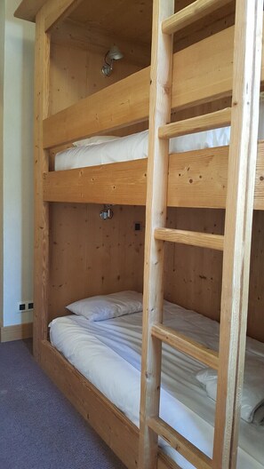 A bunk bed with a ladder, wooden walls, and a small light fixture. - Nice apt 8 ppl with sapacious terrace (Les Deux Alpes)