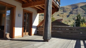 Une terrasse en bois offrant une vue sur un paysage montagneux.
