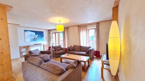 A living room with two sofas, a coffee table, a TV, and a painting on the wall. - Wonderful apt 8 ppl with mountain view (Les Deux Alpes)
