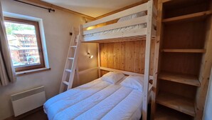 A bunk bed room with a window, a ladder, and a wall-mounted light fixture. - Wonderful apt 8 ppl with mountain view (Les Deux Alpes)