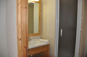 A bathroom with a wooden vanity, a sink, and a mirror.