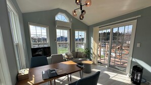 A spacious room with a dining table, chairs, a sofa, and a TV.
